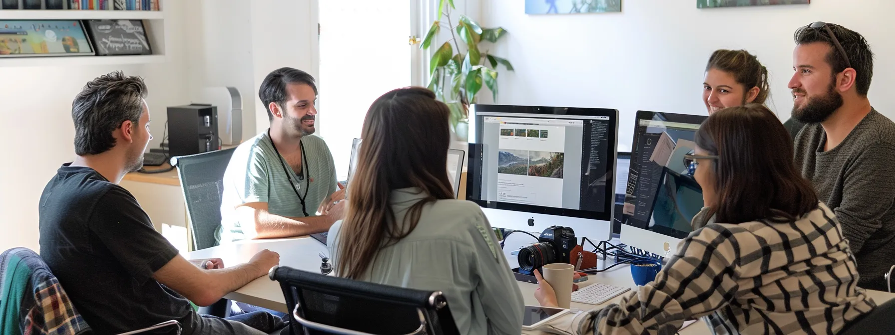 a team of web designers gathered around a computer, discussing and brainstorming ideas for a new website.